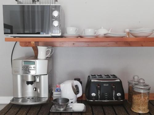 cocina con cafetera y microondas en un estante en Leeuwenhof Guesthouse en Caledon