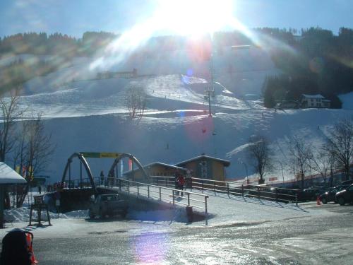 a snow covered slope with a ski lift on a mountain at Heisshof in Schladming