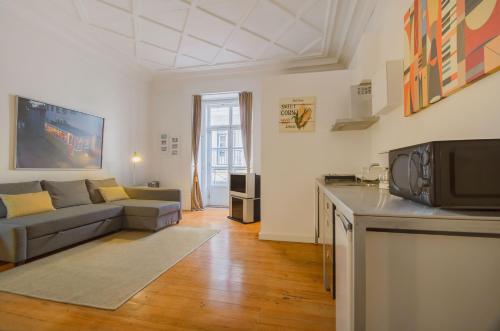 ein großes Wohnzimmer mit einem Sofa und einer Küche in der Unterkunft Chiado Balcony Apartment in Lissabon