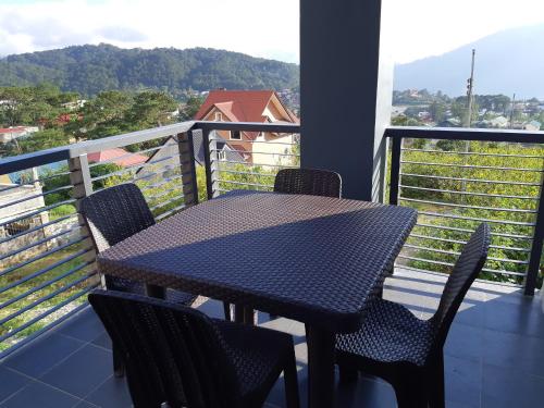 a table and chairs on a balcony with a view at Restful 3BR Hillside Duplex House in Baguio