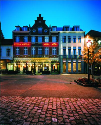 un gran edificio con letreros de neón rojo. en Hotel De Zalm, en Herentals
