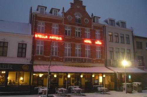 ein großes Backsteingebäude mit Neonschildern darauf in der Unterkunft Hotel De Zalm in Herentals