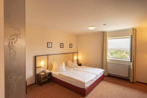 une chambre d'hôtel avec un lit et une fenêtre dans l'établissement Bergwirtschaft Wilder Mann Hotel und Restaurant, à Dresde