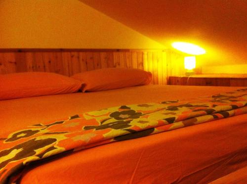 - une chambre avec un lit et une couverture colorée dans l'établissement Rododendro, à Frabosa Sottana