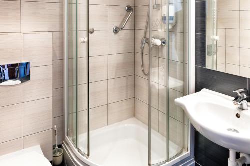 a bathroom with a shower and a sink at Focus Hotel Gdańsk in Gdańsk