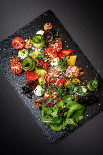 a plate of food with fruit and vegetables on a table at Rija VEF Hotel with FREE Parking in Rīga
