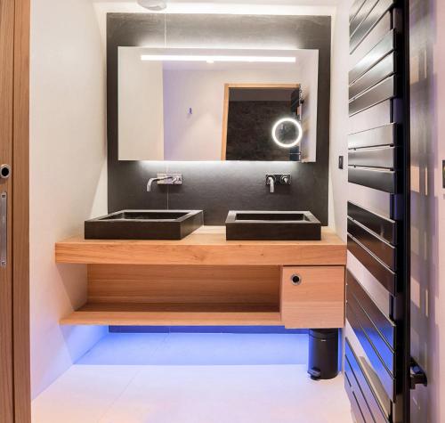 a bathroom with two sinks and a mirror at Hôtel Interlaken Lounge Bar & Spa in Xonrupt-Longemer