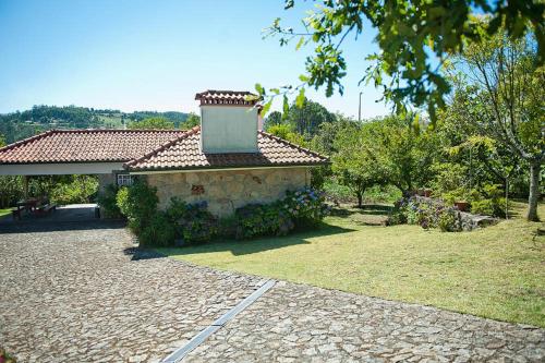 un bâtiment en pierre avec un toit sur une cour dans l'établissement Casa Boavista, à Paredes de Coura