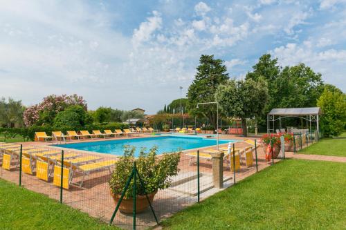 a large swimming pool with chairs at Relais La Pieve Vecchia in Riparbella