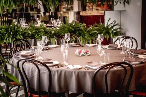 a long table with glasses and plates and chairs at Rija VEF Hotel with FREE Parking in Rīga