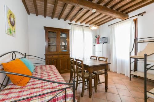 a bedroom with a bed and a table and a desk at Relais La Pieve Vecchia in Riparbella