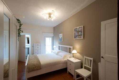 a bedroom with a white bed and a chair at San Frediano 56 in Florence