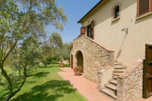 a building with a brick walkway next to a yard at Relais La Pieve Vecchia in Riparbella