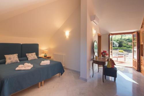 a bedroom with a bed and a table and a window at Il Giardino di Venere in Mondello
