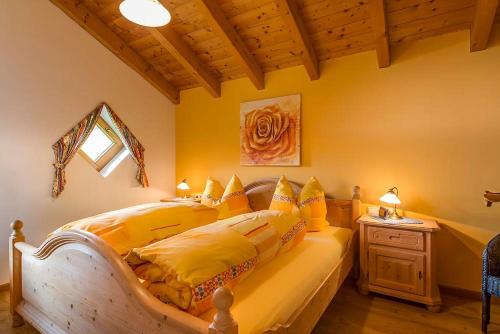 1 dormitorio con 1 cama grande con almohadas amarillas en Landhaus Kaufmann, en Bad Hindelang