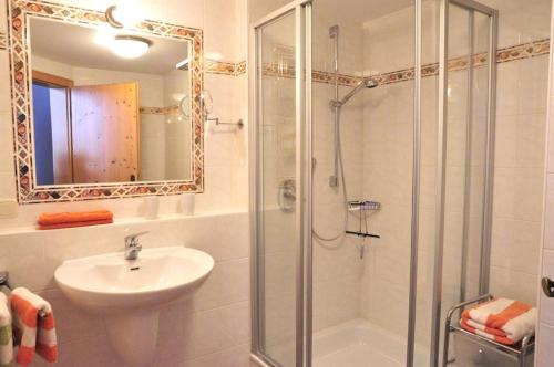 y baño con ducha, lavabo y espejo. en Landhaus Kaufmann, en Bad Hindelang