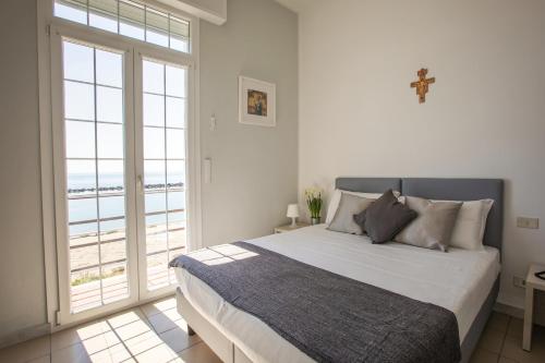 a bedroom with a bed with a view of the ocean at Casa F.A.C.I in Marina di Massa