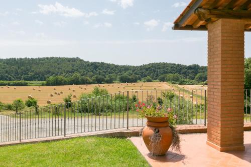 a large vase sitting on a patio with a fence at Relais La Pieve Vecchia in Riparbella
