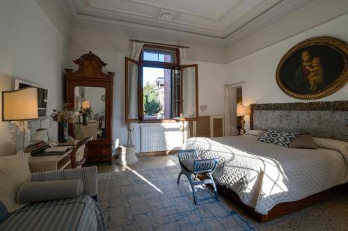 a bedroom with a bed and a desk and a window at Ca' della Corte in Venice