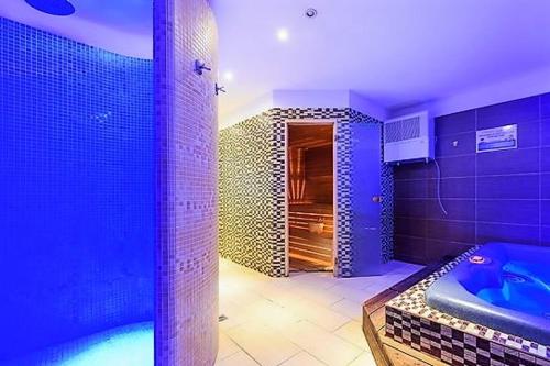 a blue bathroom with a tub and a shower at RS Budoucnost in Frýdlant nad Ostravicí