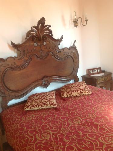 a bed with a large wooden headboard in a bedroom at Casa Boavista in Paredes de Coura