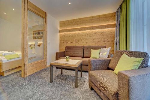 a living room with a couch and a table and a bed at Appart-Hotel Wildererstuben in Bodenmais