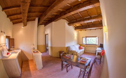 a kitchen and living room with a table and a couch at Vocabolo Monache in Ponte Pattoli
