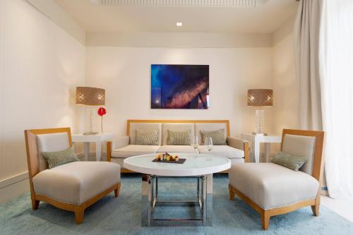 a living room with a couch and a table and chairs at Meliá Genova in Genova