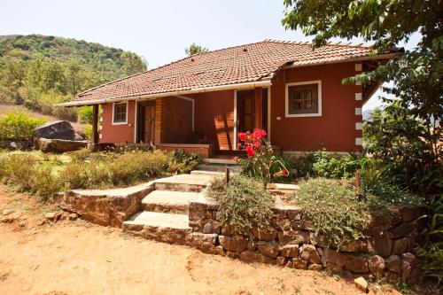 a small house with a stone path leading to it at Kabbe Holidays in Madikeri