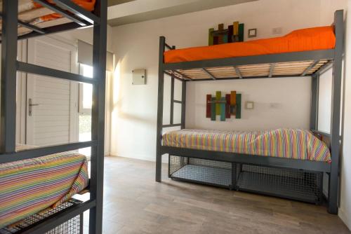 ネウケンにあるBernardino Hostel Boutiqueの二段ベッド2台と廊下が備わる客室です。