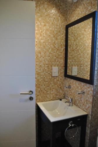 a bathroom with a sink and a mirror and a shower at Bernardino Hostel Boutique in Neuquén