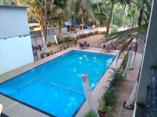 an overhead view of a blue swimming pool with palm trees at Hotel Murud Marina in Murud