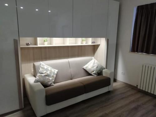 a couch in a living room with two pillows on it at Indipendent Luxury Mini Apartment in Pescara