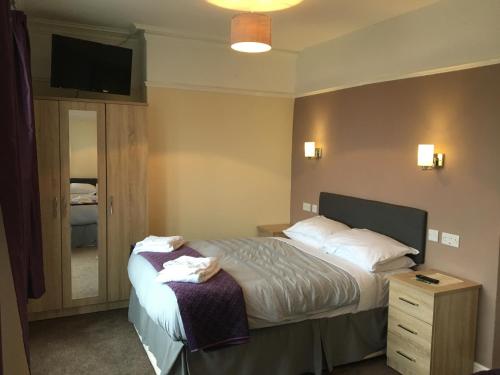 a hotel room with a bed and a television at The Waverley Hotel Maryport in Maryport