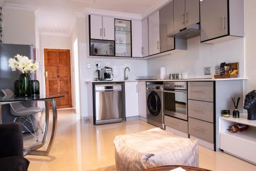 a kitchen with stainless steel appliances and a table at The Wilcrest Apartment in Randjesfontein