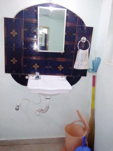 a bathroom with a sink and a mirror at Hotel Rosary House in Malvan