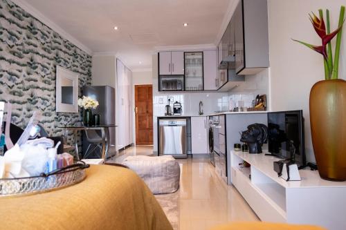 a living room with a kitchen and a room with a couch at The Wilcrest Apartment in Randjesfontein
