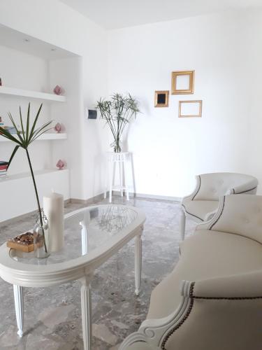 a white living room with a table and chairs at Dimora TerraNostra&Spa in Ugento