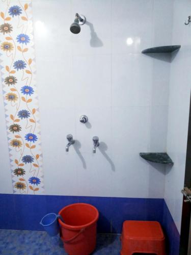 a bathroom with two faucets and a bucket at Hotel Rosary House in Malvan
