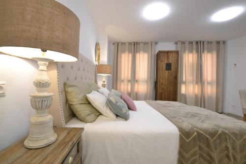 a bedroom with a bed with a lamp and pillows at Cozy Studio Alicante in Alicante