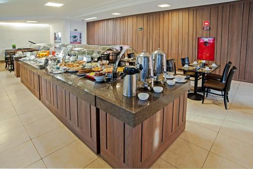 a buffet line with food on it in a restaurant at The Hill Hotéis Executive in São Carlos