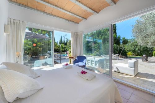 a bedroom with a white bed and a large window at New! Villa Can Colomaret Carmen in Santa Eularia des Riu