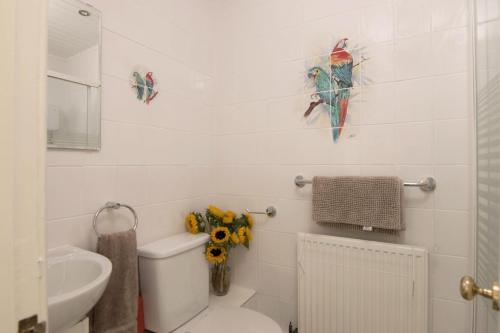 a bathroom with a toilet and some birds on the wall at Quiet, Convenient, Hawick Flat in Hawick