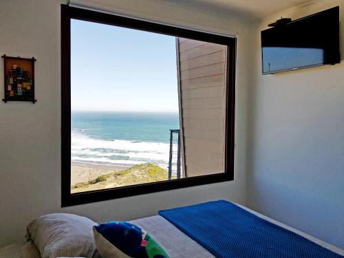 a bedroom with a large window with a view of the ocean at Tiny Apartment Las Puyas Ocean View in Boca Pupuya