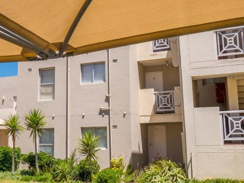 an apartment building with palm trees in front of it at 123 hbc in Hermanus