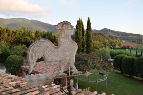 a statue of a chicken on top of a brick wall at TENUTA I TUFARI in Tivoli