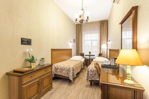 Habitación de hotel con 2 camas y espejo en Ligotel, en San Petersburgo