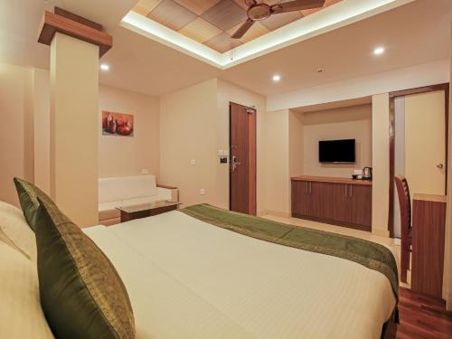a bedroom with a large bed with a ceiling fan at Treebo Goodland Residency - 500m from Railway Station in Trivandrum