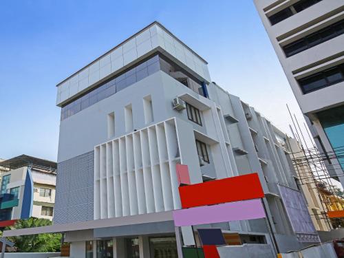 a tall white building with colorful squares on it at Treebo Trend Goodland Residency in Trivandrum