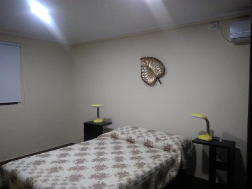 1 dormitorio con 1 cama y 2 mesas con lámparas en ZUHAUSE en Puerto Iguazú